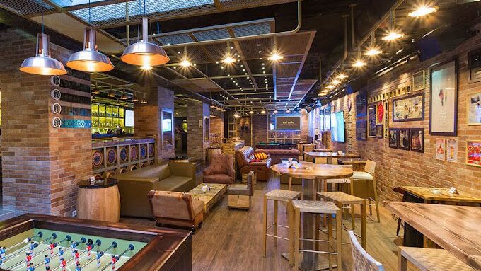 Interior of MindHub in Rabieh, Amman — exposed brick, pendant lighting, high tables with stools and a lounge seating area