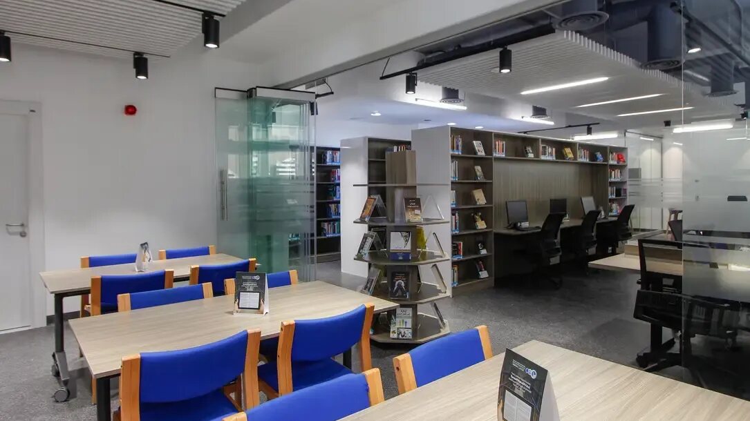Reading room at the Abdul Hameed Shoman Public Library in Jabal Amman, with study desks, blue chairs, bookshelves and computer stations